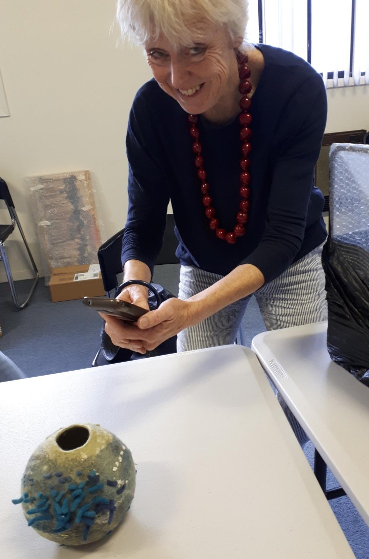 Steph photographing artwork with her mobile phone